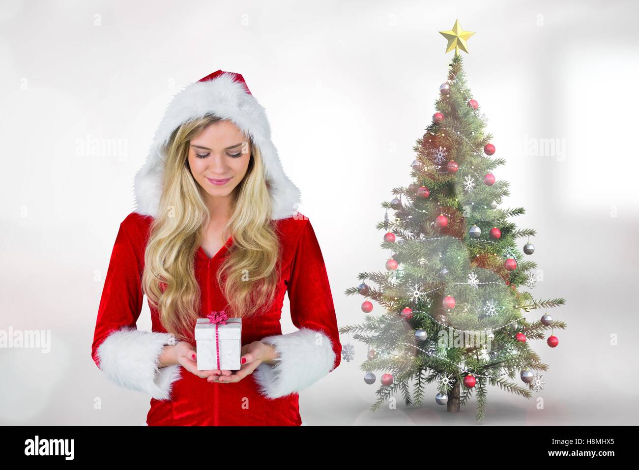 Beautiful woman in santa costume holding a gift Stock Photo