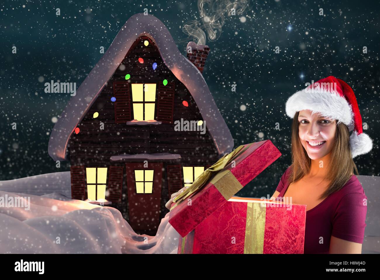 Portrait of woman in santa hat opening christmas gift Stock Photo