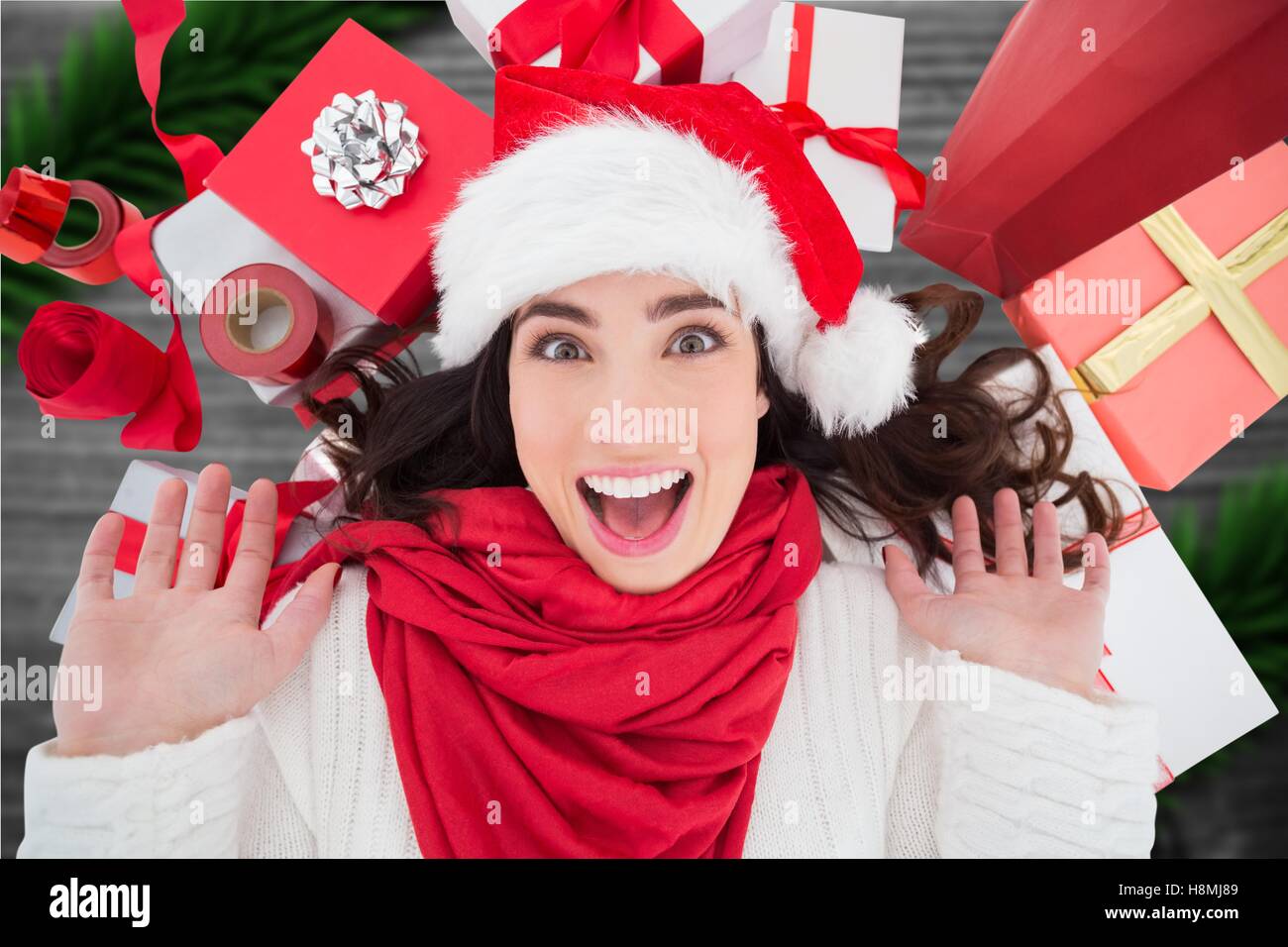 Excited woman in santa hat against digitally generated background Stock Photo