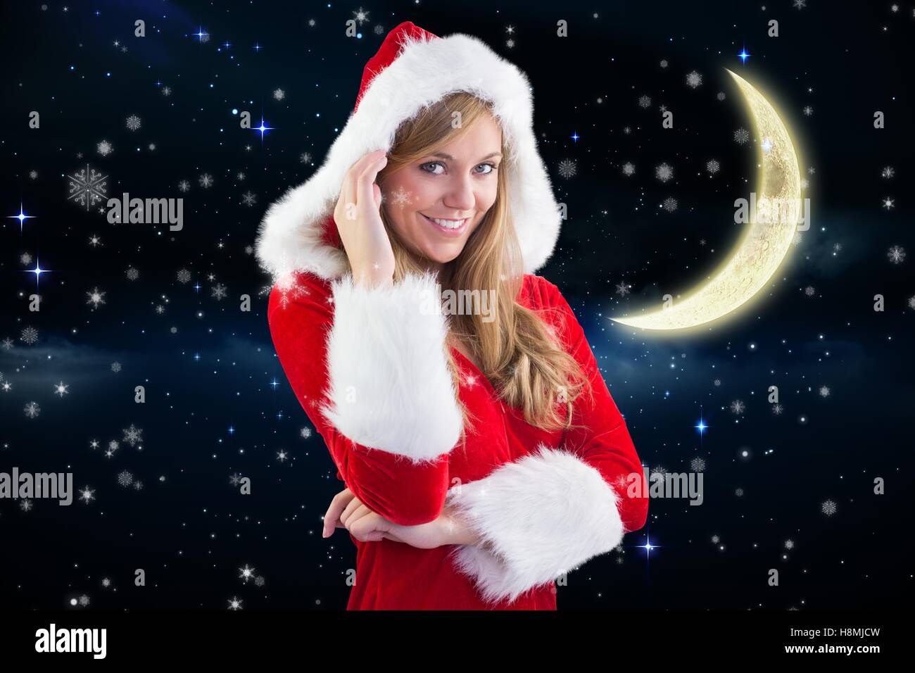 Beautiful girl in santa costume smiling at camera against digitally generated background Stock Photo