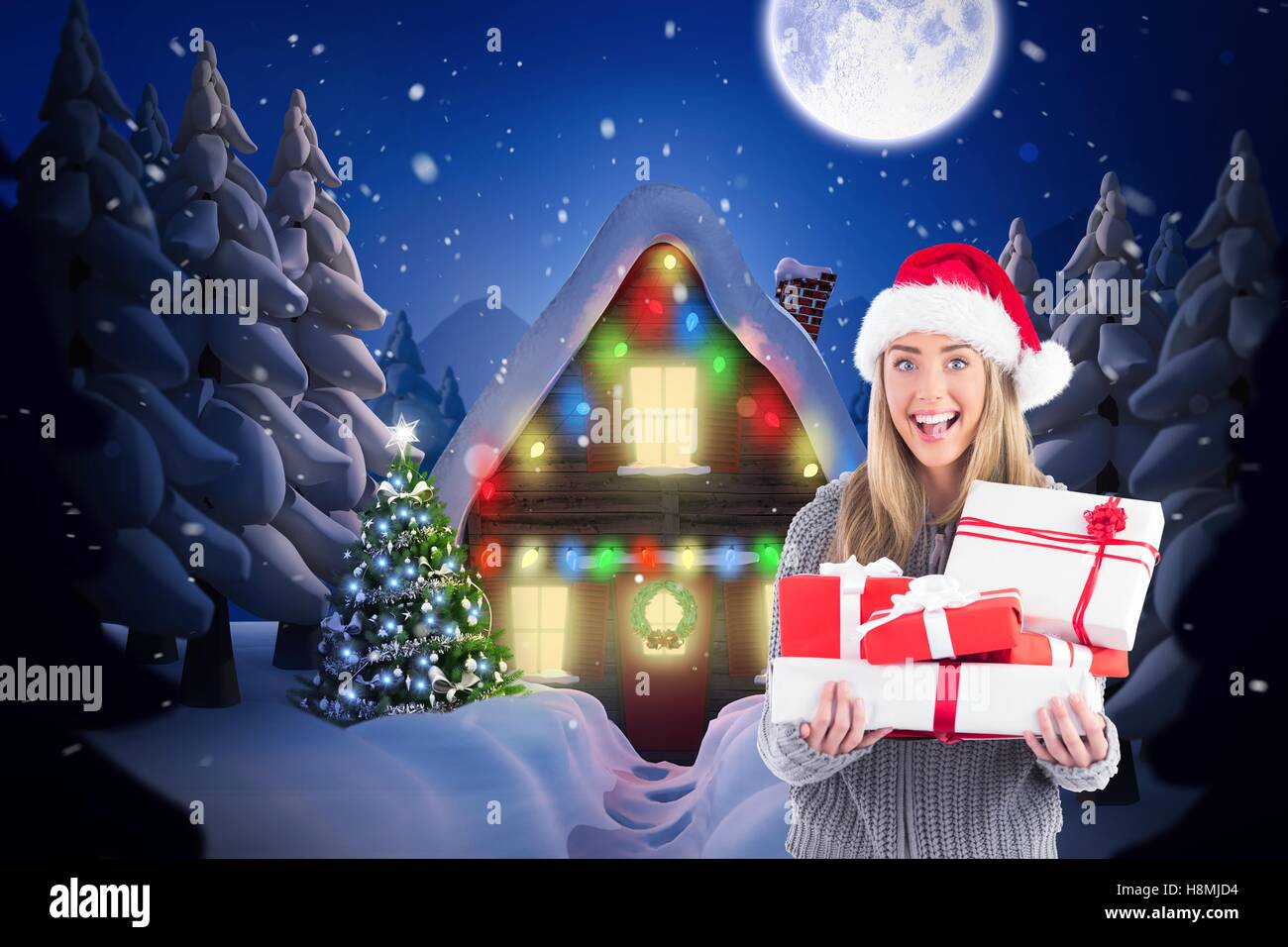 Beautiful woman in santa hat holding a christmas gift Stock Photo
