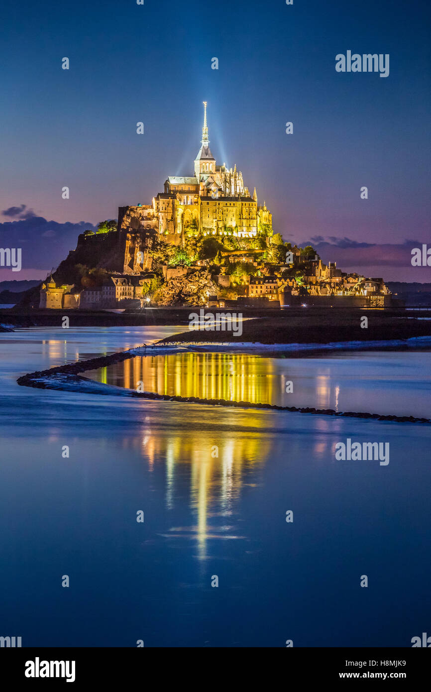 Classic view of famous Le Mont Saint-Michel tidal island in beautiful twilight during blue hour at dusk, Normandy, France Stock Photo