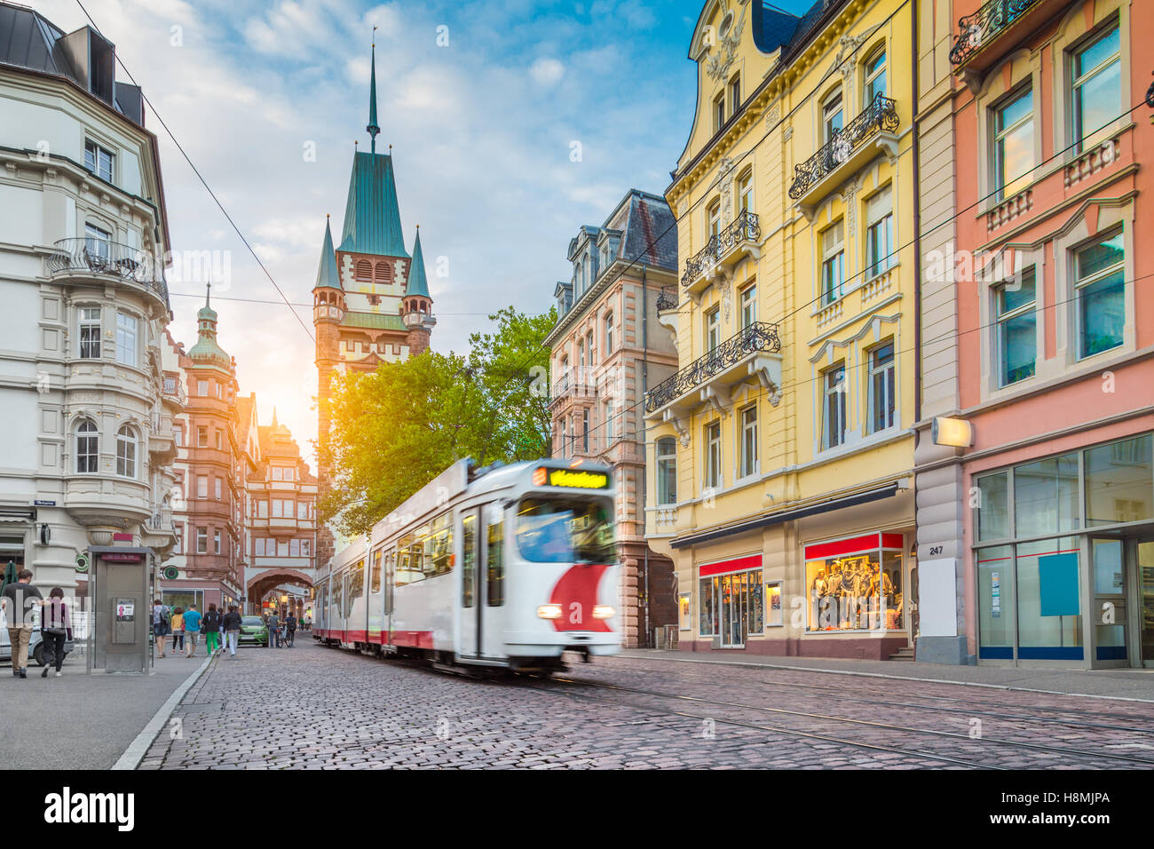 Historic town of Freiburg im Breisgau with traditional tram and famous Martin's Gate at sunset, Baden-Wurttemberg, Germany Stock Photo