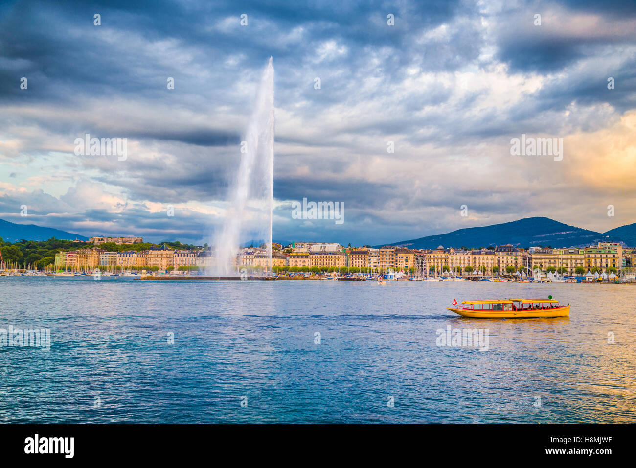 Classic view of Geneva skyline with famous Jet d'Eau fountain at Lake Geneva in beautiful evening light at sunset, Switzerland Stock Photo