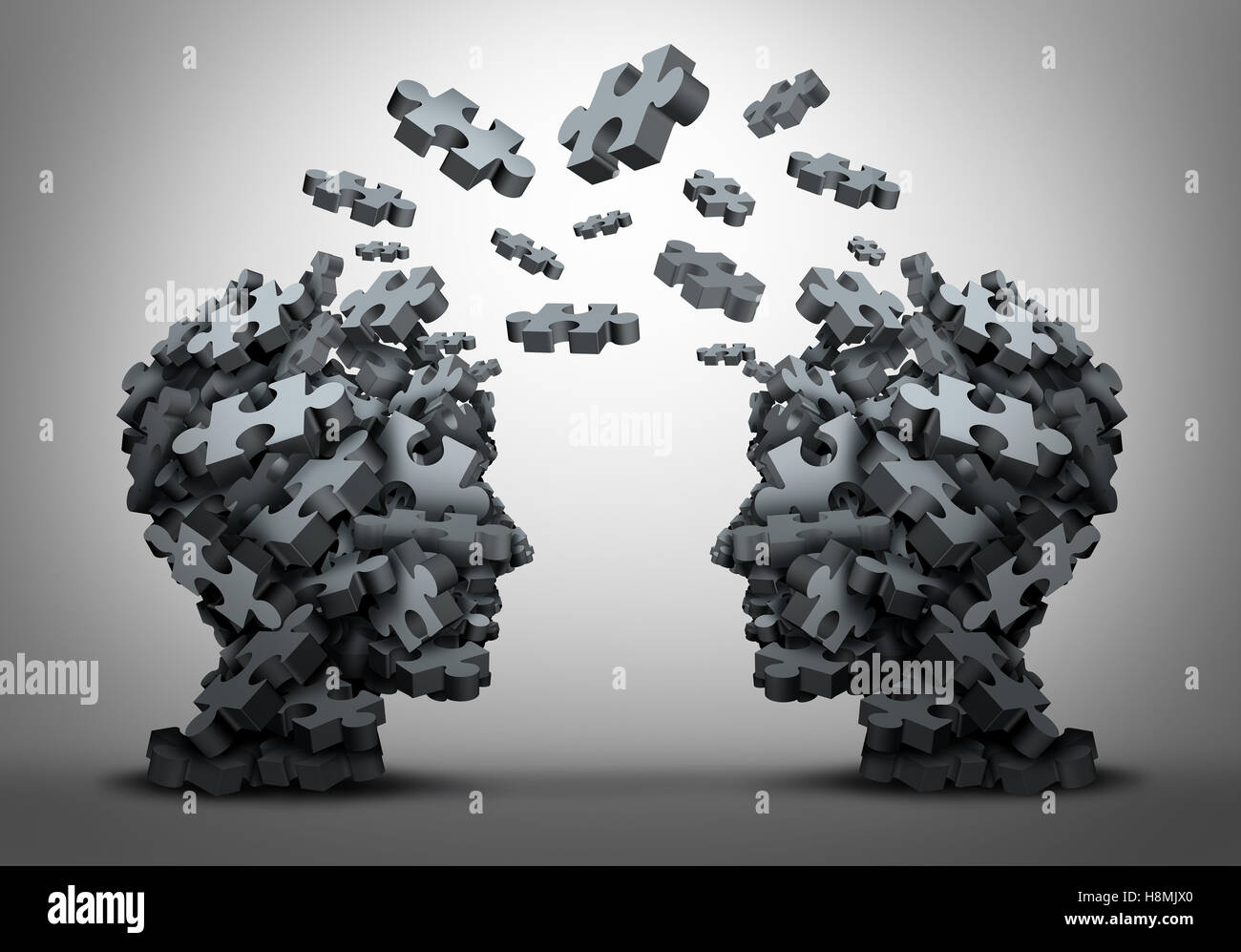 Solution exchange and transfer of ideas concept as a group of jigsaw puzzle pieces shaped as two human heads exchanging answers Stock Photo