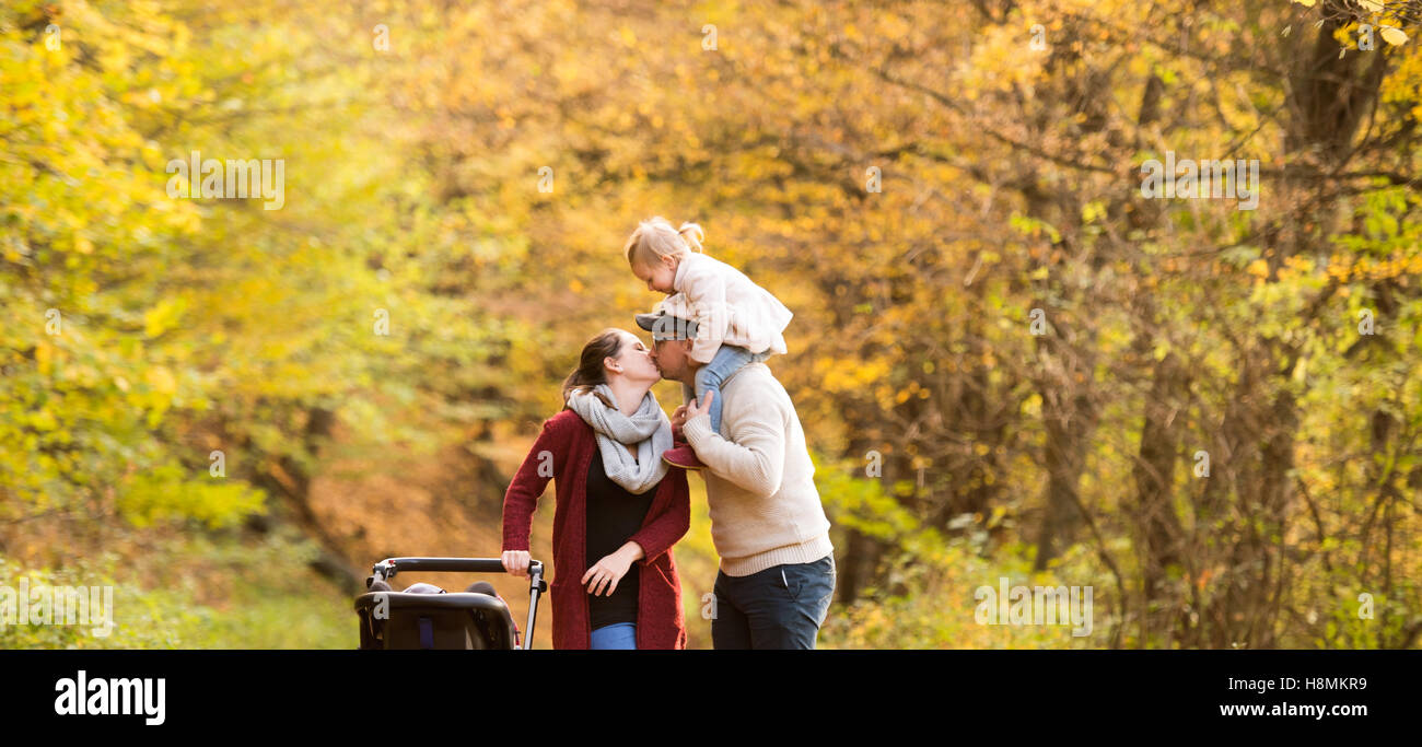 Beautiful young family on a walk in autumn forest Stock Photo - Alamy
