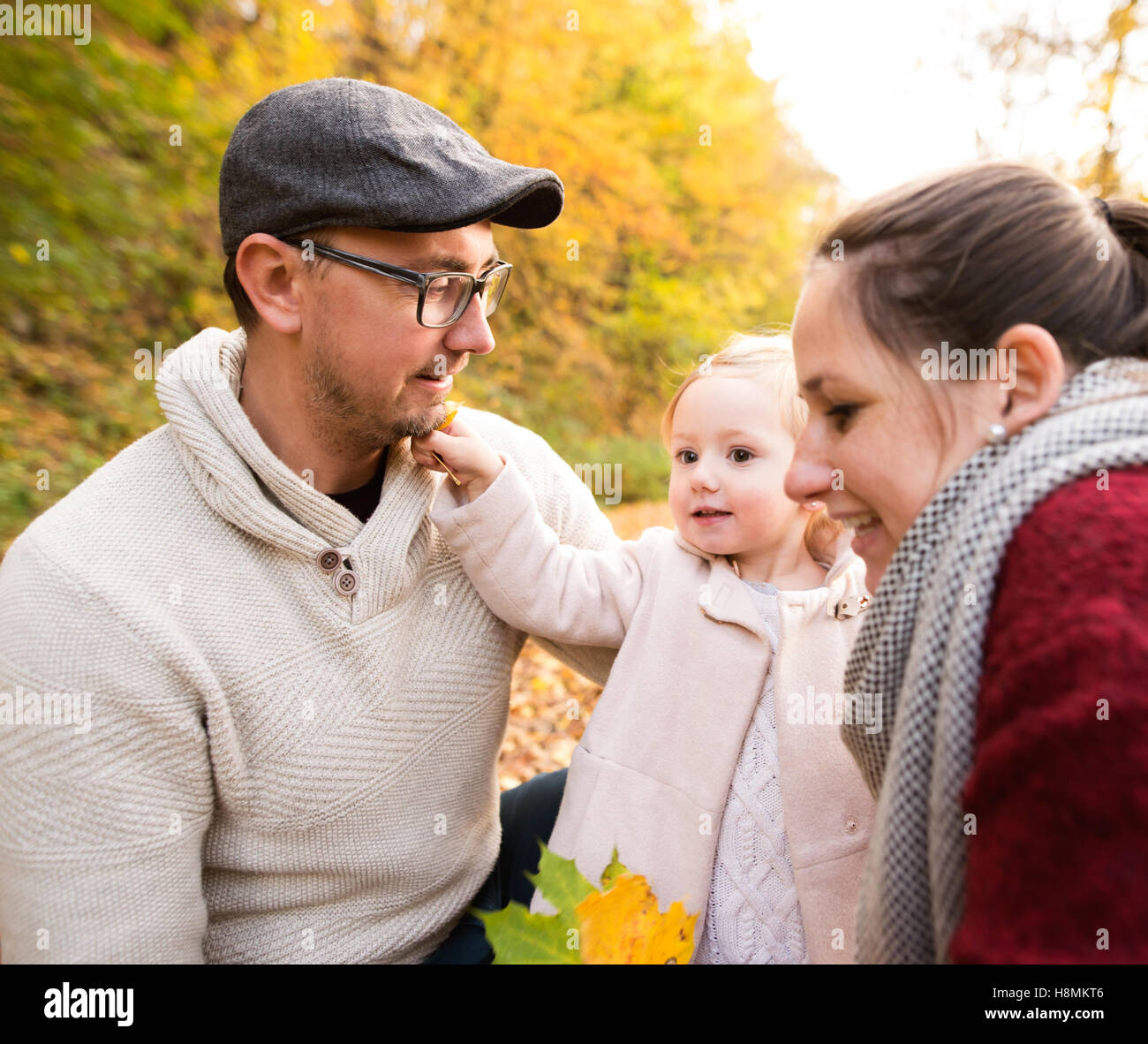 Beautiful young family on a walk in autumn forest Stock Photo - Alamy