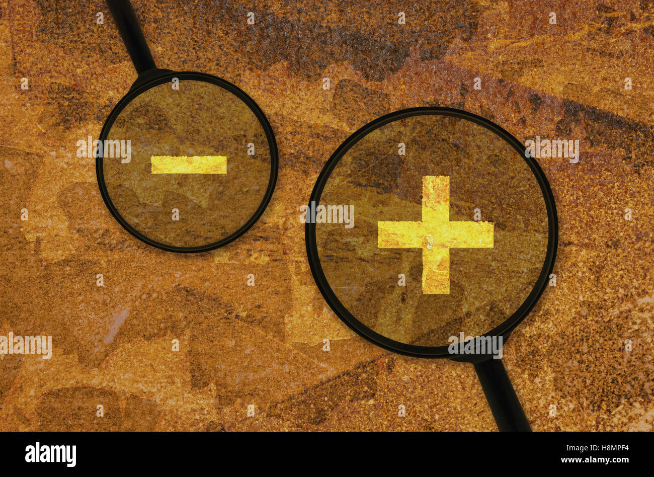 Mathematical signs for addition and subtraction under a magnifier Stock Photo