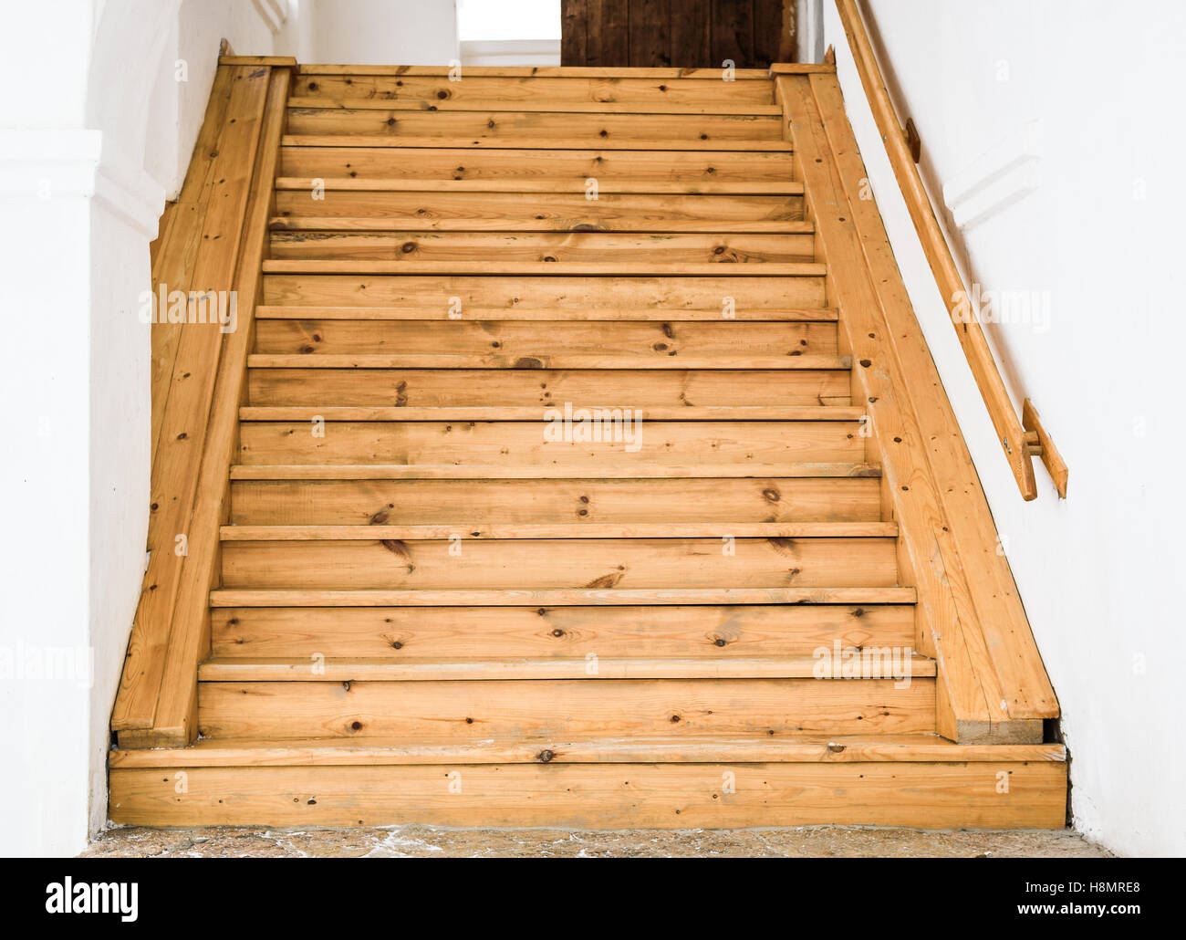 the wooden staircase and railing against white walls Stock Photo