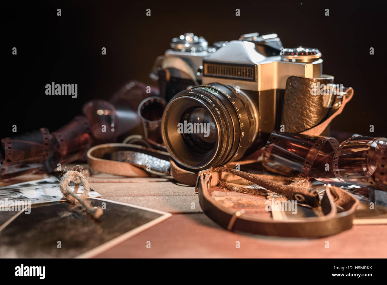 Old retro vintage camera, photos and film on a dark background Stock Photo
