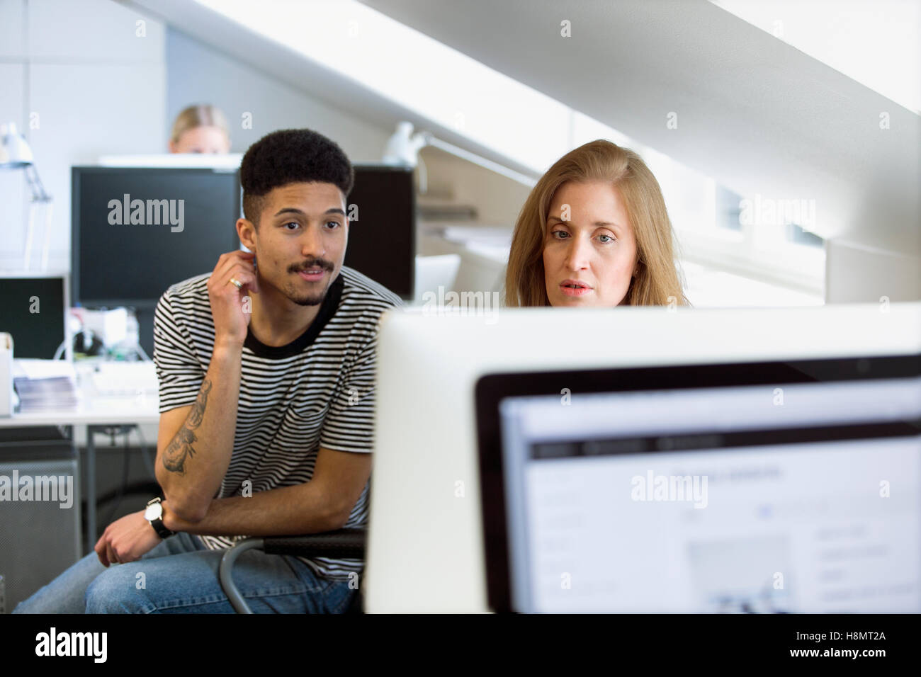 Two office workers looking at computer screen in office Stock Photo