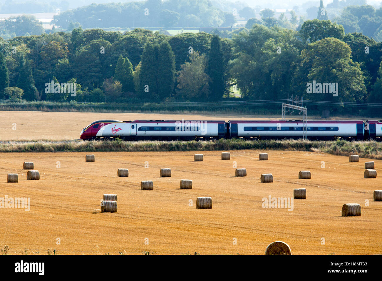 A Virgin train traveling between Atherstone to Polesworth on Trent Valley line. Stock Photo