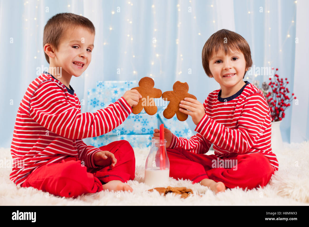 Child Getting Two Cookies Two happy children eating cookies at christmas and drinking milk ...