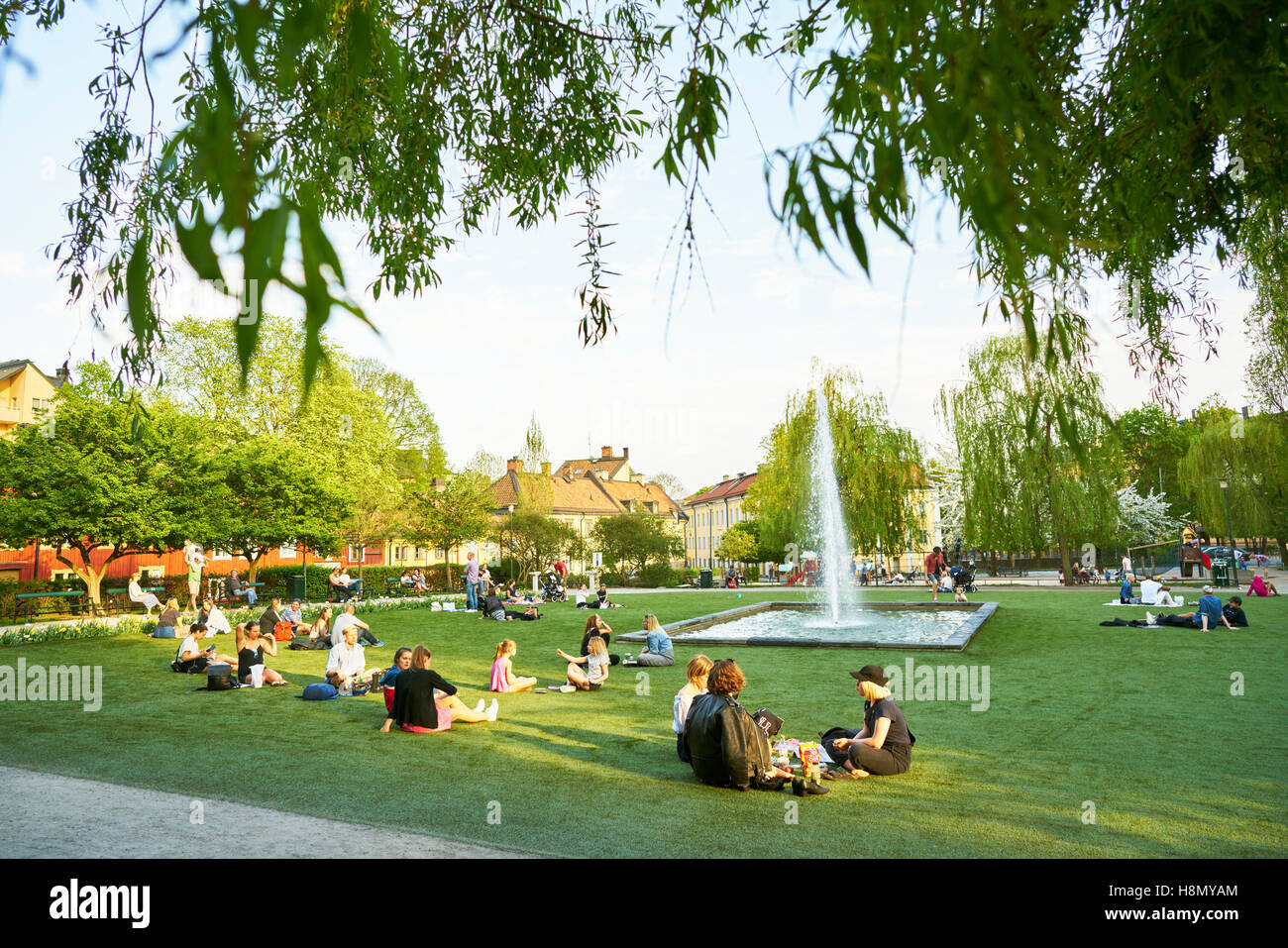 People resting on grass in park Stock Photo