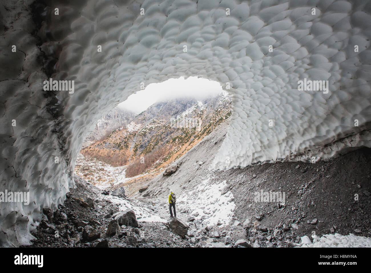 Man standing inside large cave Stock Photo