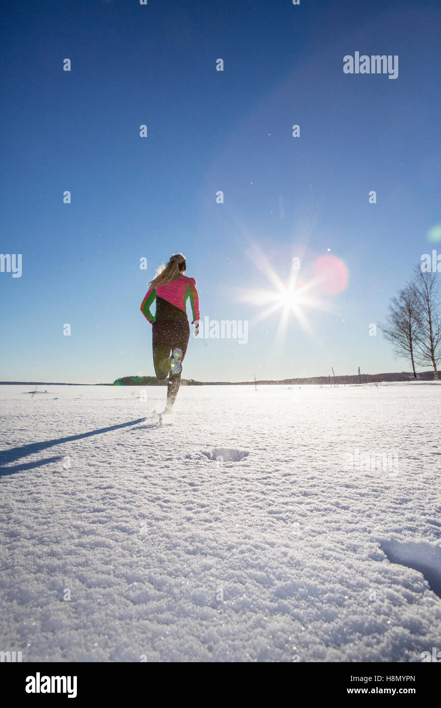 Woman running on snowy day Stock Photo