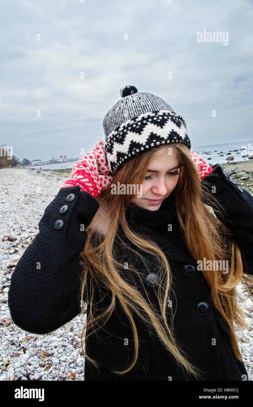 Blonde young woman with long hair in woolly hat Stock Photo
