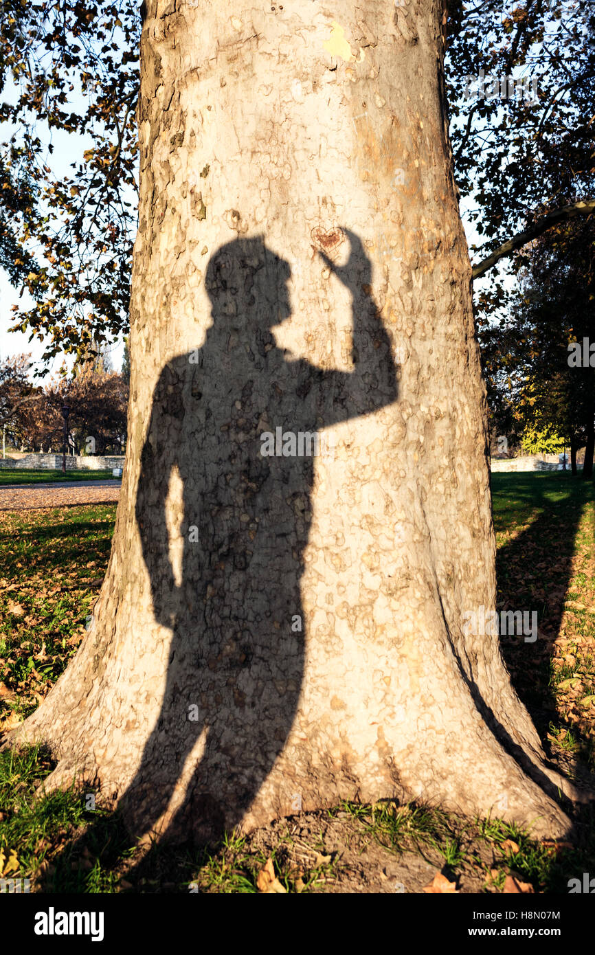Mans shadow holding heart Stock Photo