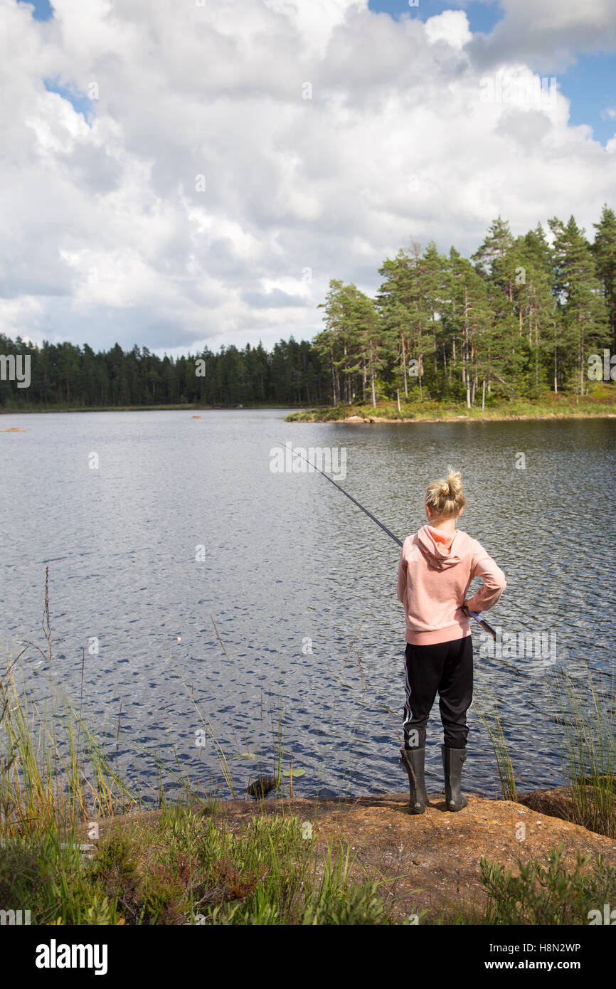 Girl (12-13) fishing in lake Stock Photo - Alamy
