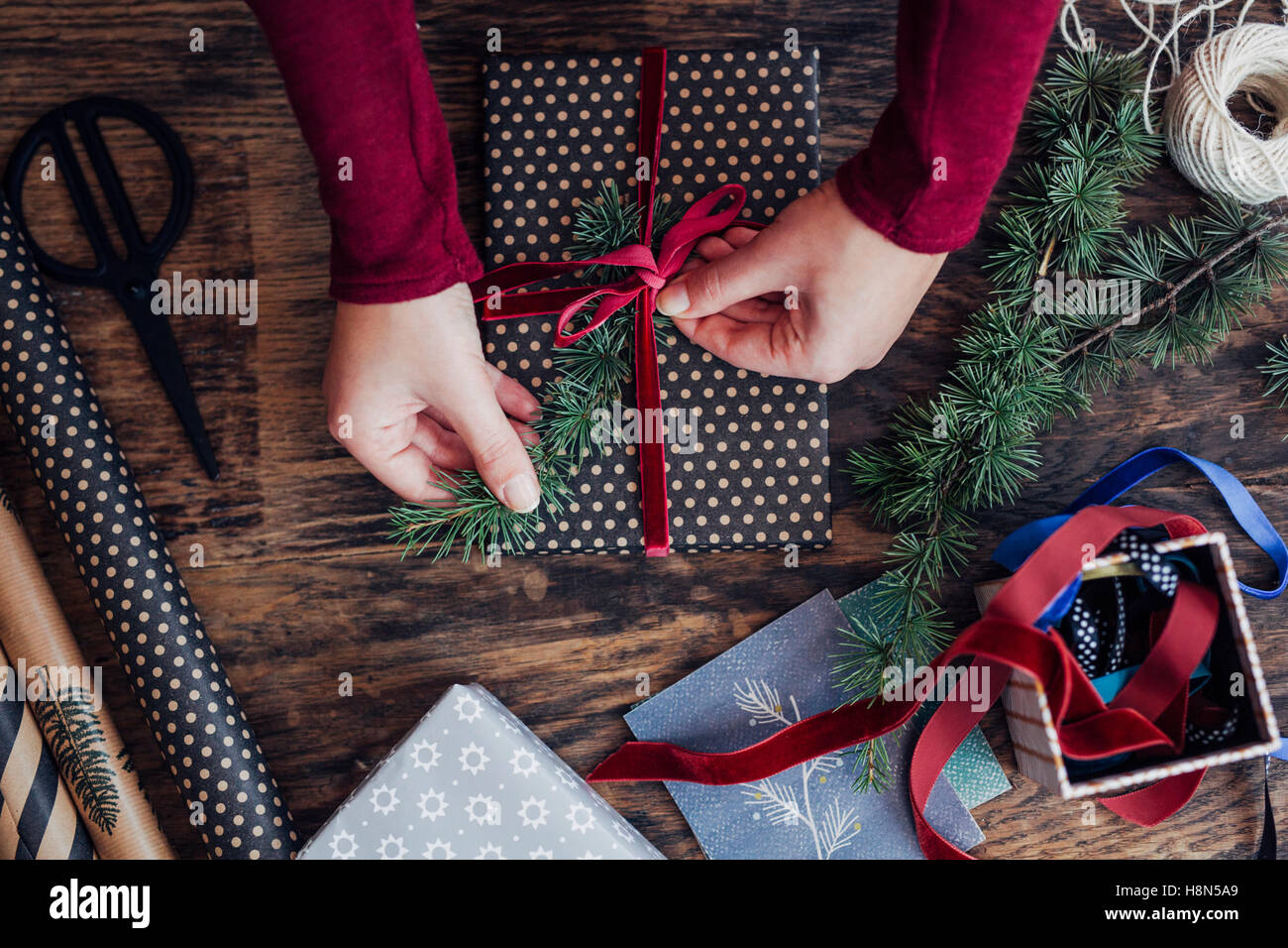 Woman Tying Ribbon on Christmas Present Stock Photo