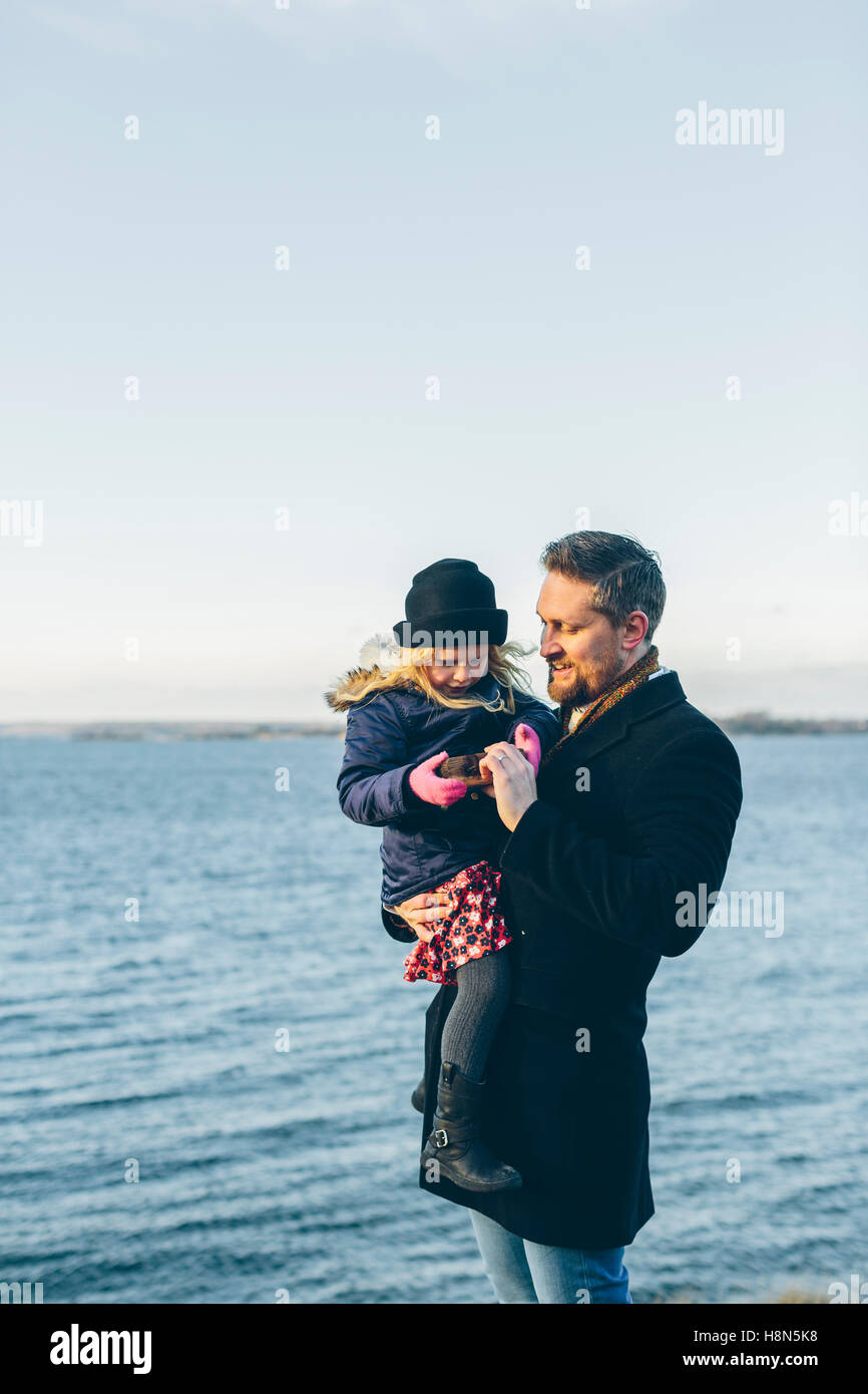 Father with daughter (4-5) standing by sea Stock Photo