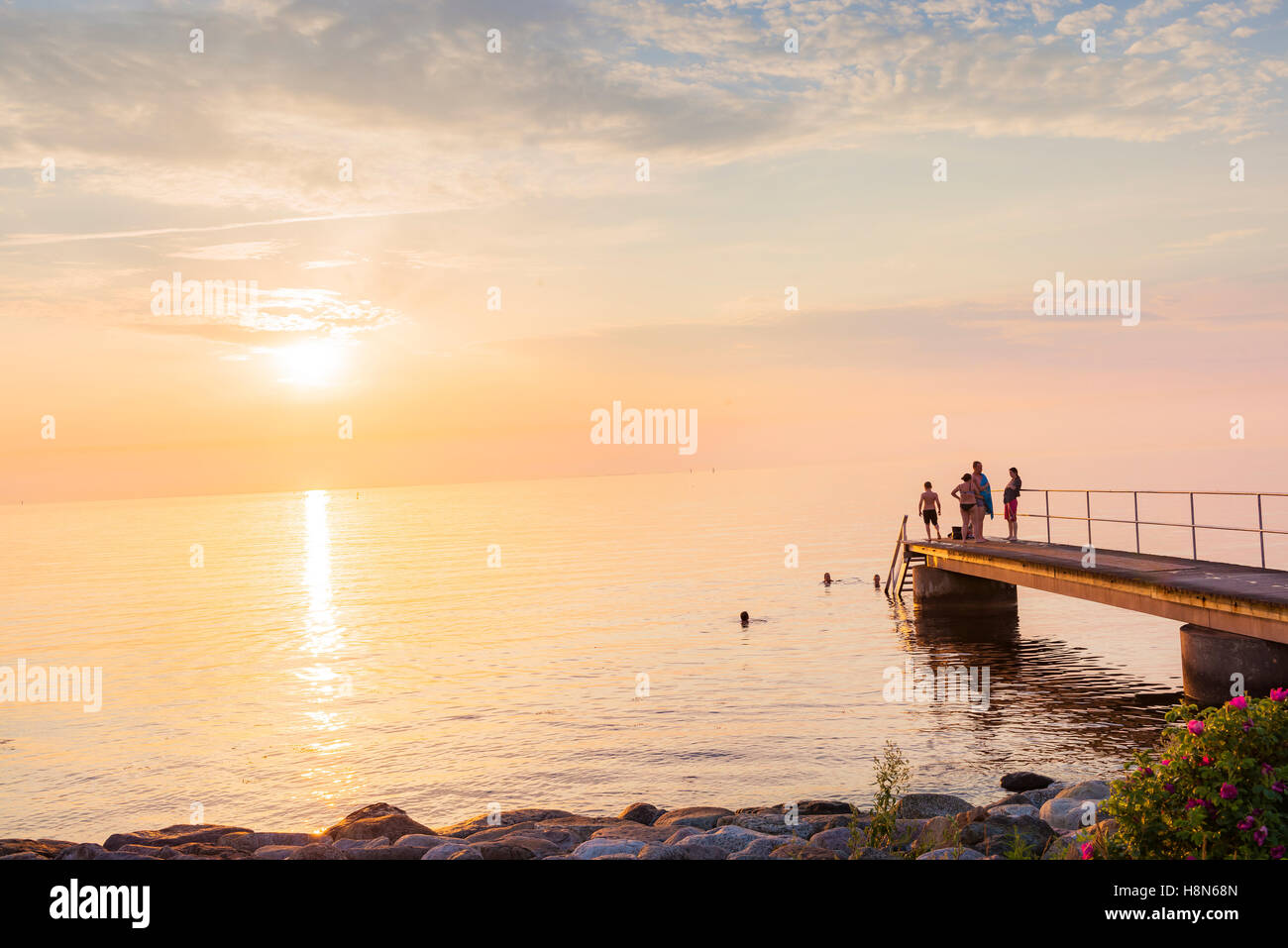 Sweden, Skane, Malmo, Sibbarp, People pier at sunset Stock Photo