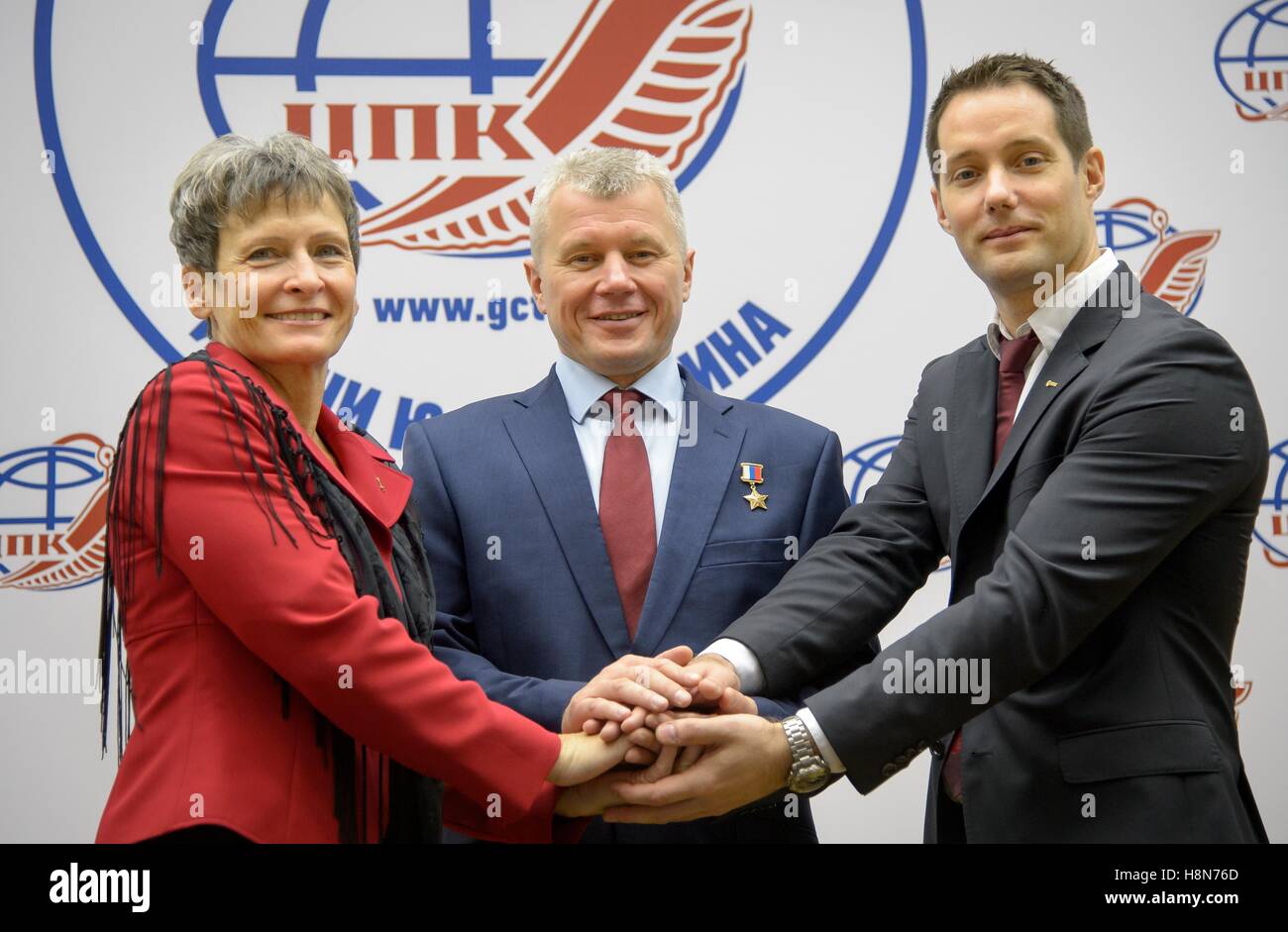 NASA International Space Station Expedition 50 Soyuz MS-03 prime crew members (L-R) American astronaut Peggy Whitson, Russian cosmonaut Oleg Novitskiy of Roscosmos, and French astronaut Thomas Pesquet of the European Spac Agency join hands during a group photo after a crew press conference at the Gagarin Cosmonaut Training Center October 26, 2016 in Star City, Russia. Stock Photo