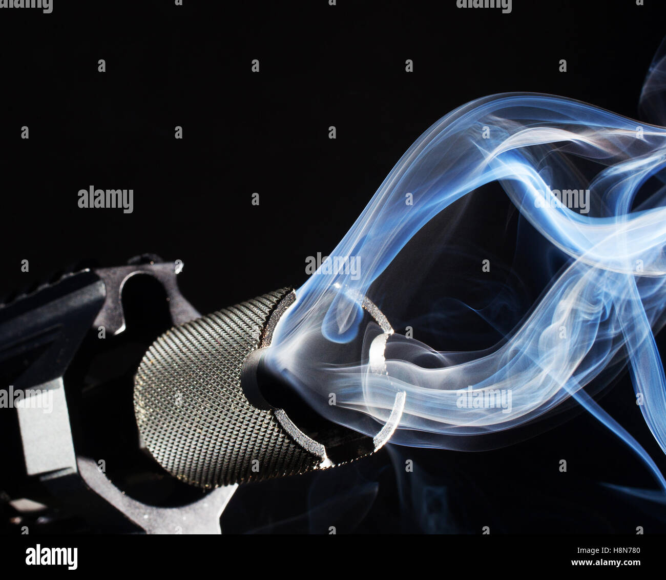 Lots of smoking coming from the barrel of an assault weapon Stock Photo