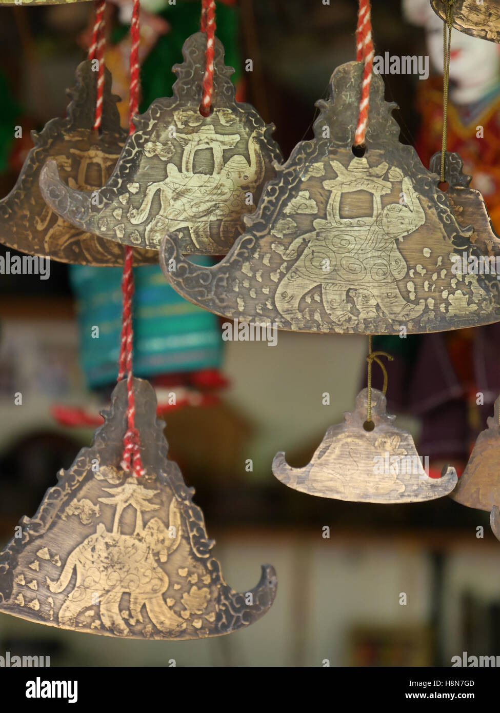 Close up of display of small triangular metallic bells hanging on market stall, traditional Burmese design and popular as souvenirs Stock Photo