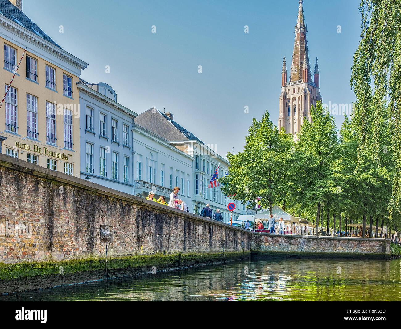 Canal With The Spire Of Church of Our Lady Bruges Belgium Stock Photo