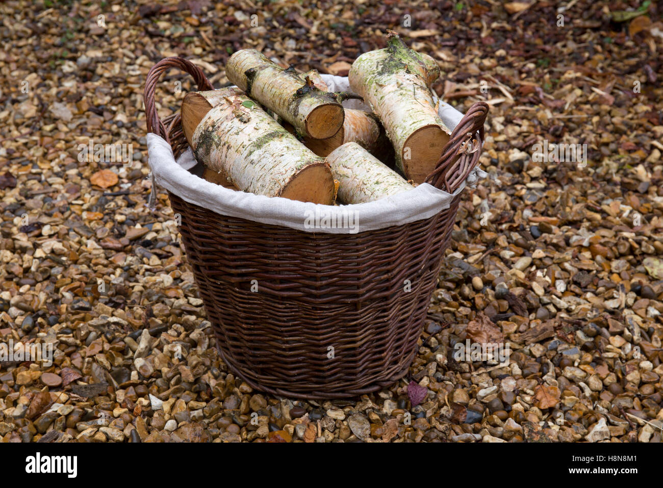 Wicker Basket full of logs for fire,England Stock Photo