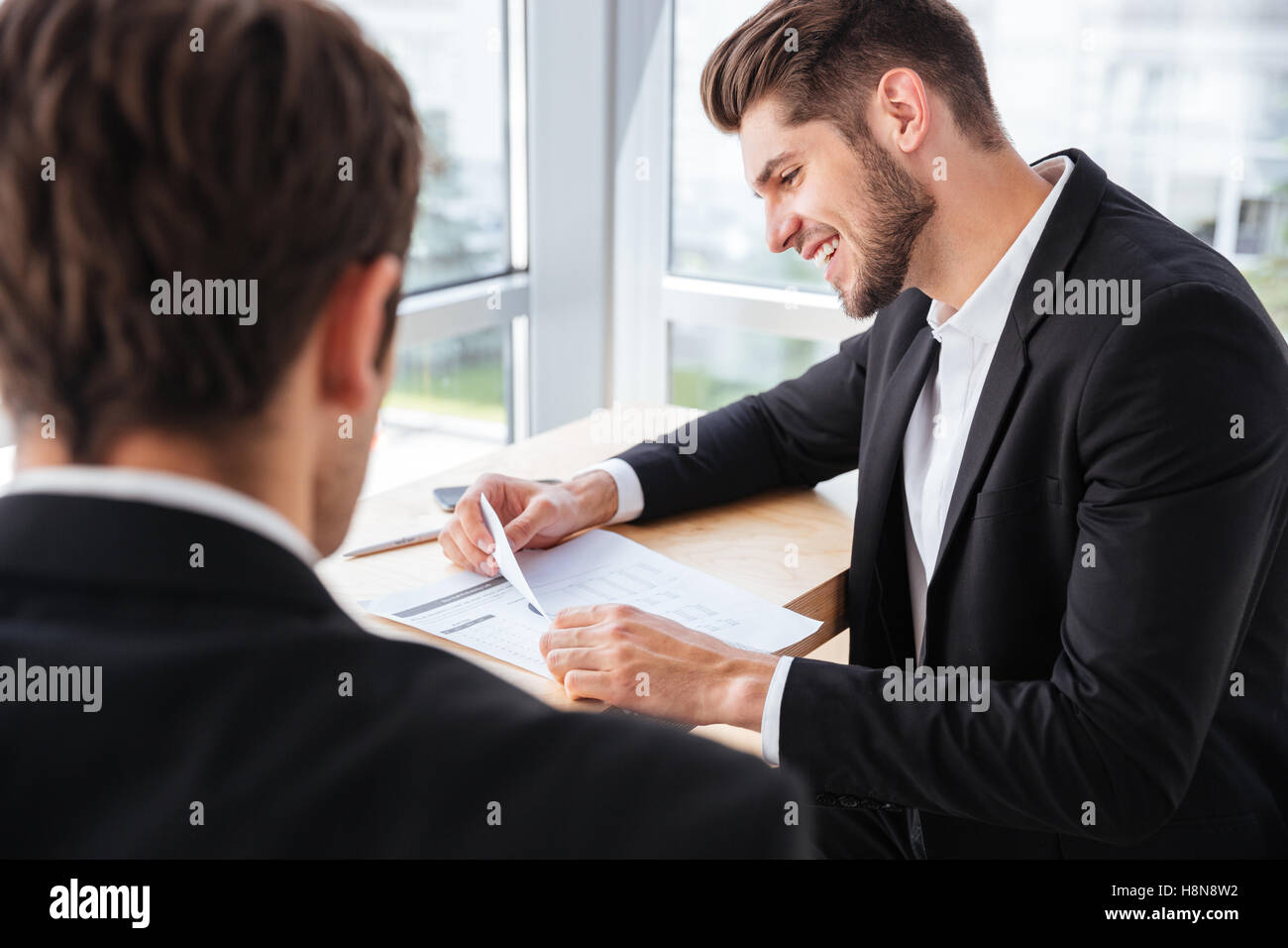 Two happy young businessmen discussing business plan together in office Stock Photo