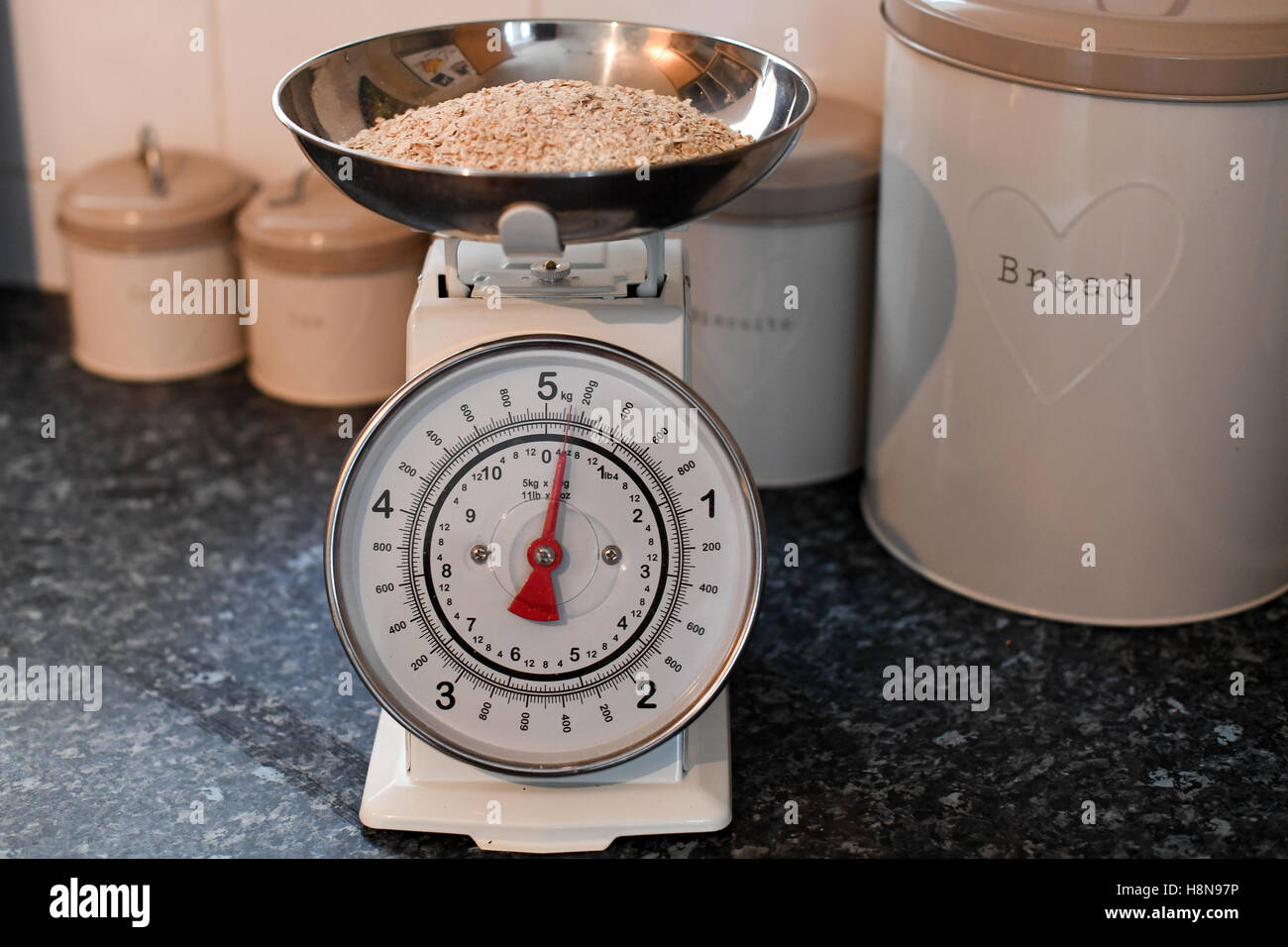https://c8.alamy.com/comp/H8N97P/weighing-scales-in-a-kitchen-environment-with-porridge-oats-in-the-H8N97P.jpg