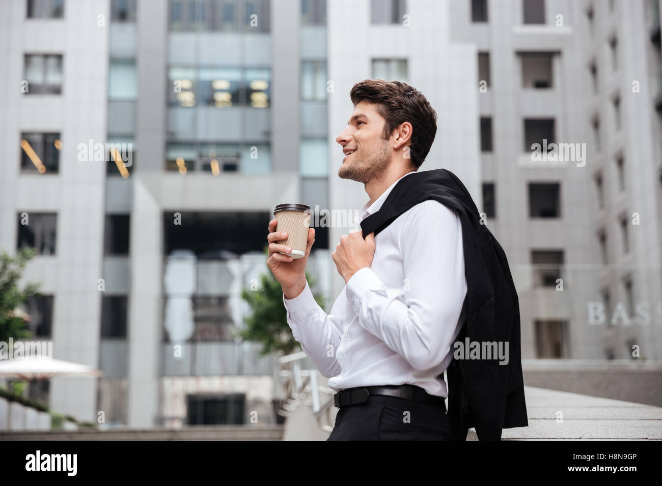 Cheerful young businessman drinking coffee in the city Stock Photo - Alamy