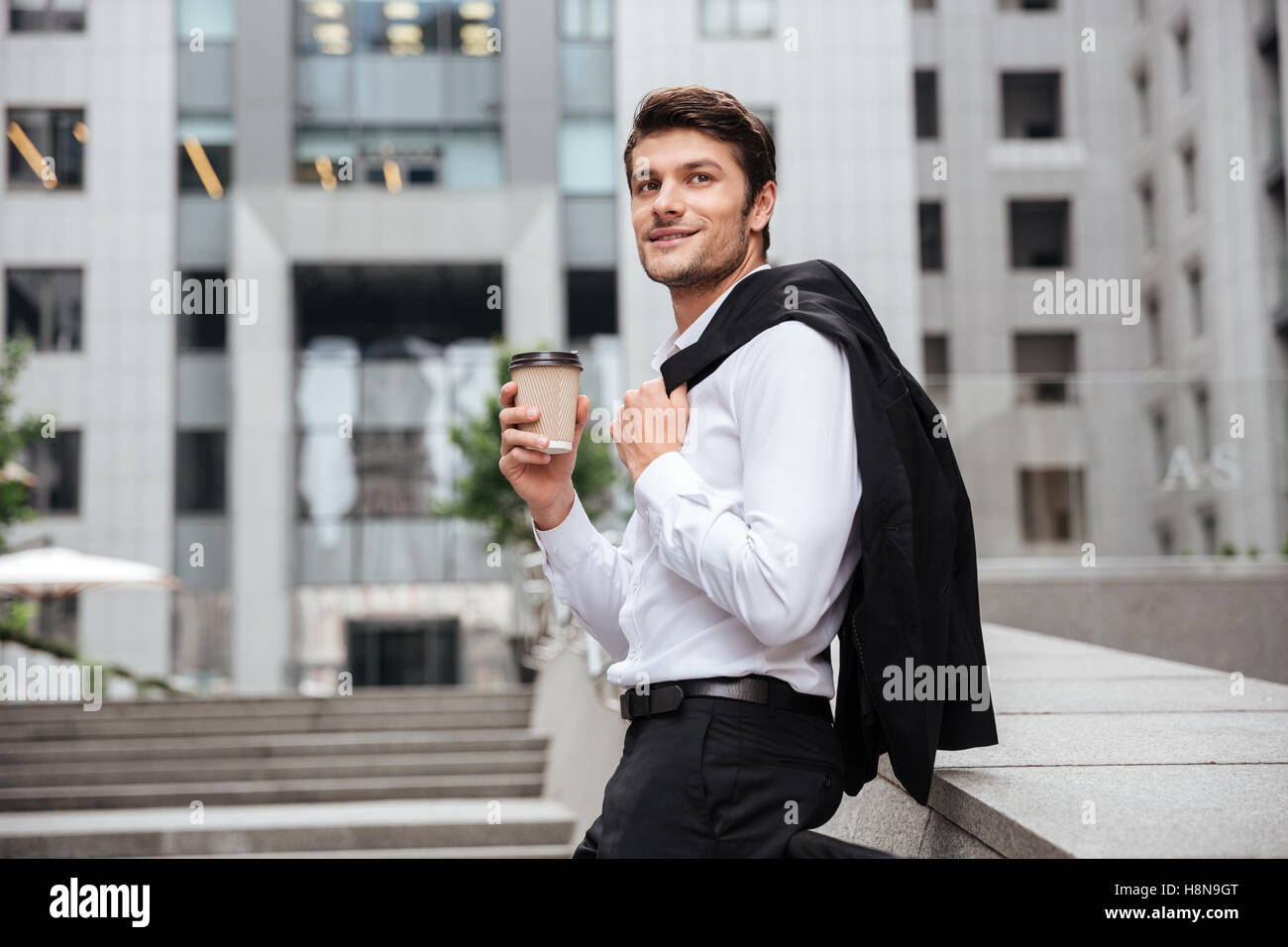 Happy young businessman standing and drinking coffee in the city Stock ...