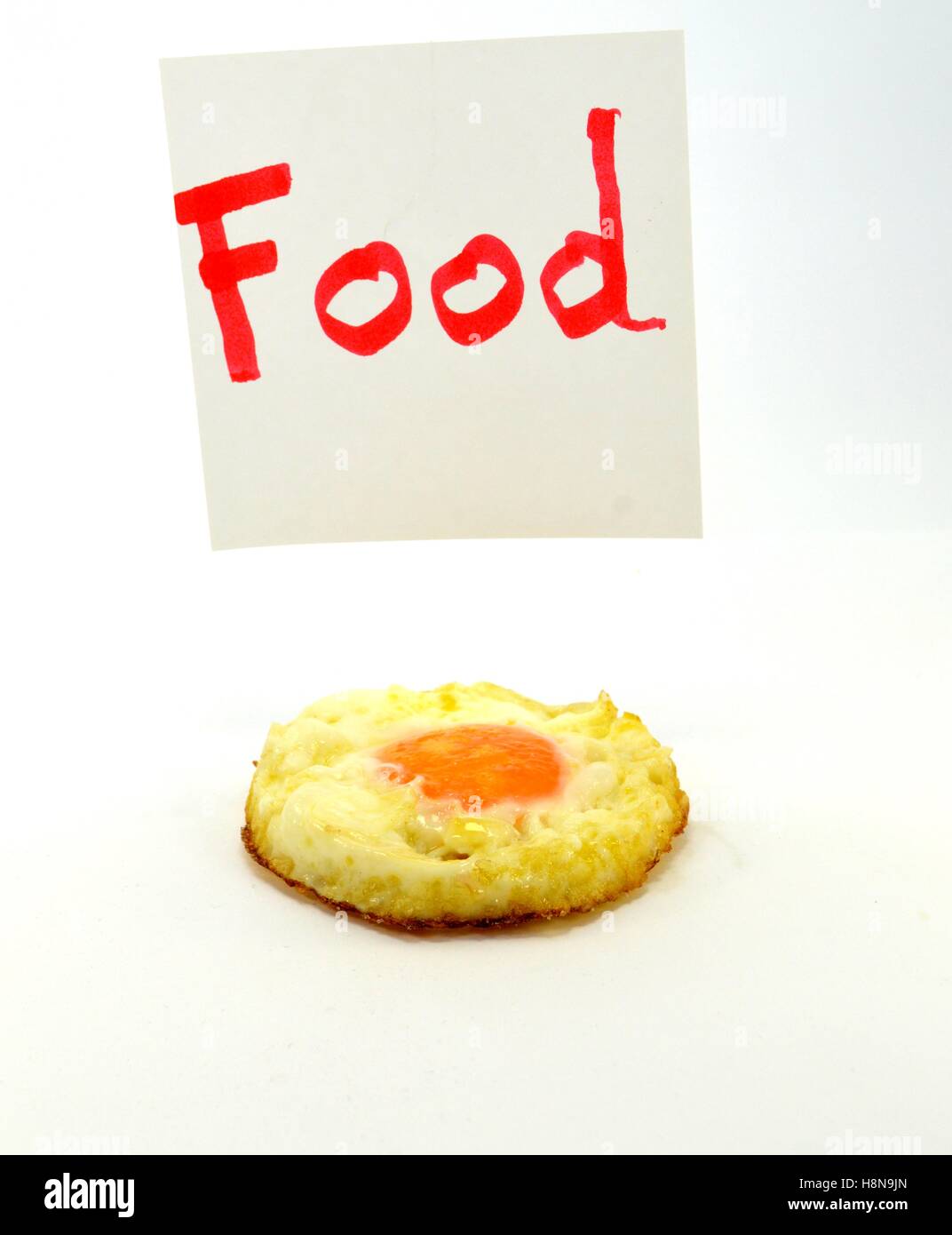 Mot Food written in red letters with an egg on the flat on a white background Stock Photo