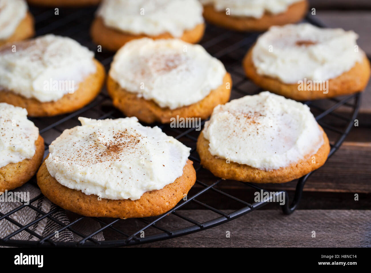 Homemade pumpkin spice cake cookies with glaze and cinnamon on cooling rack Stock Photo