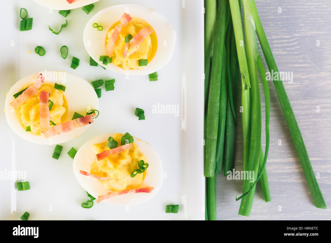 Deviled eggs garnished with green onions and bacon Stock Photo Alamy