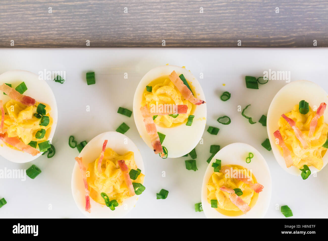 Deviled eggs garnished with green onions and bacon Stock Photo Alamy