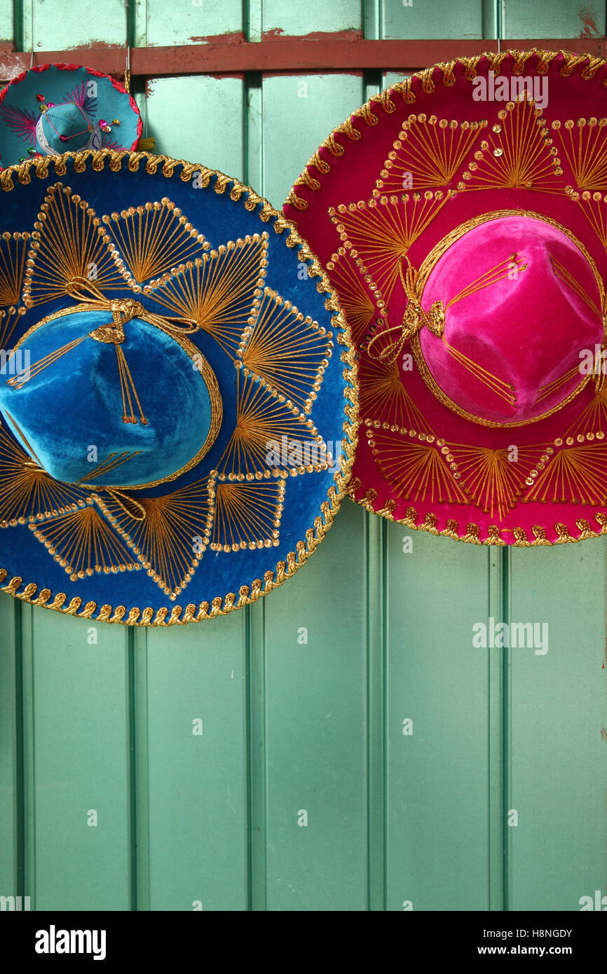 Colorful blue & pink Mexican hats hanging on a green door, Cozumel, Quintana Roo, Mexico. Stock Photo