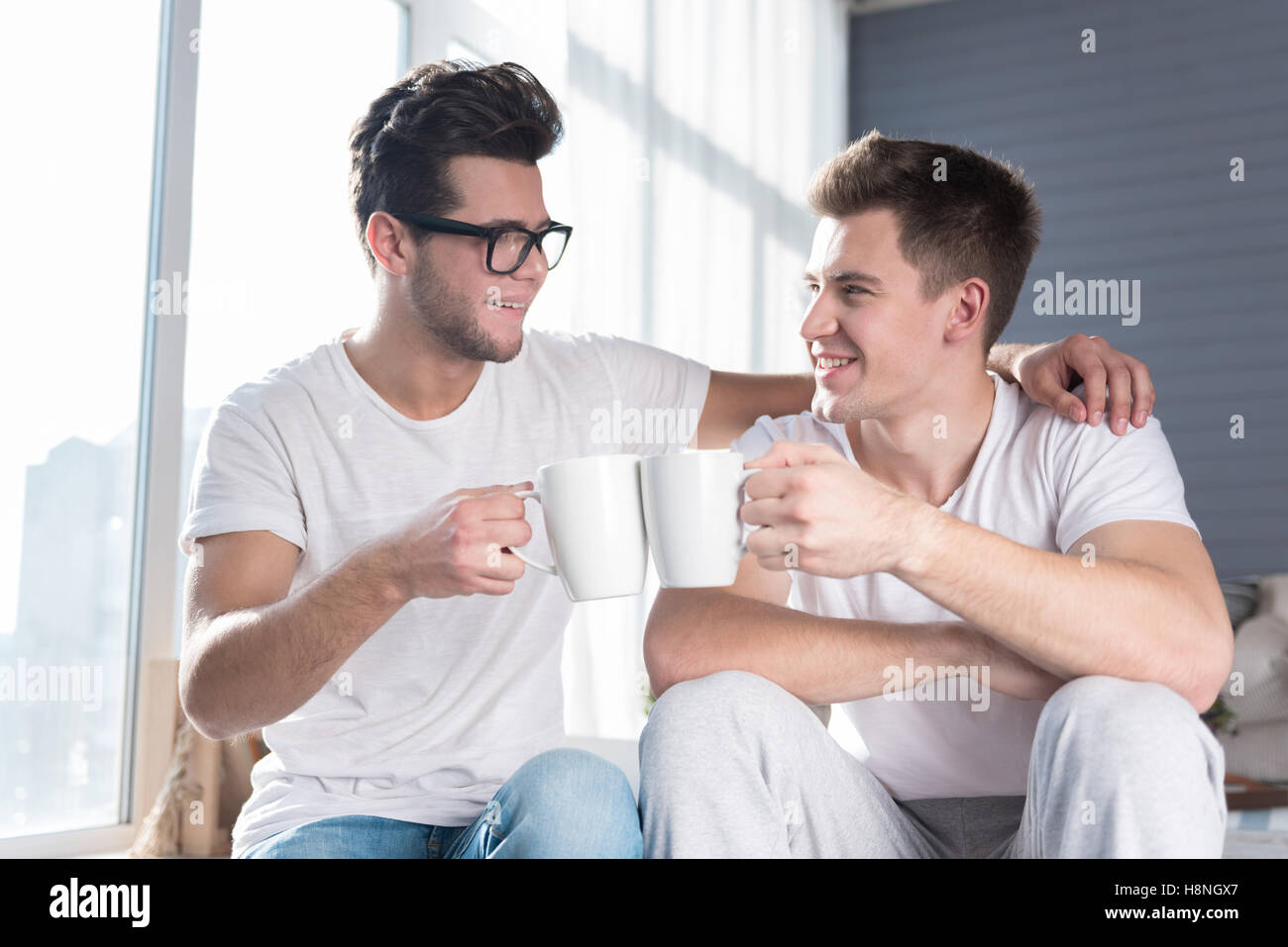 Homosexual couple having a hot drink together. Stock Photo