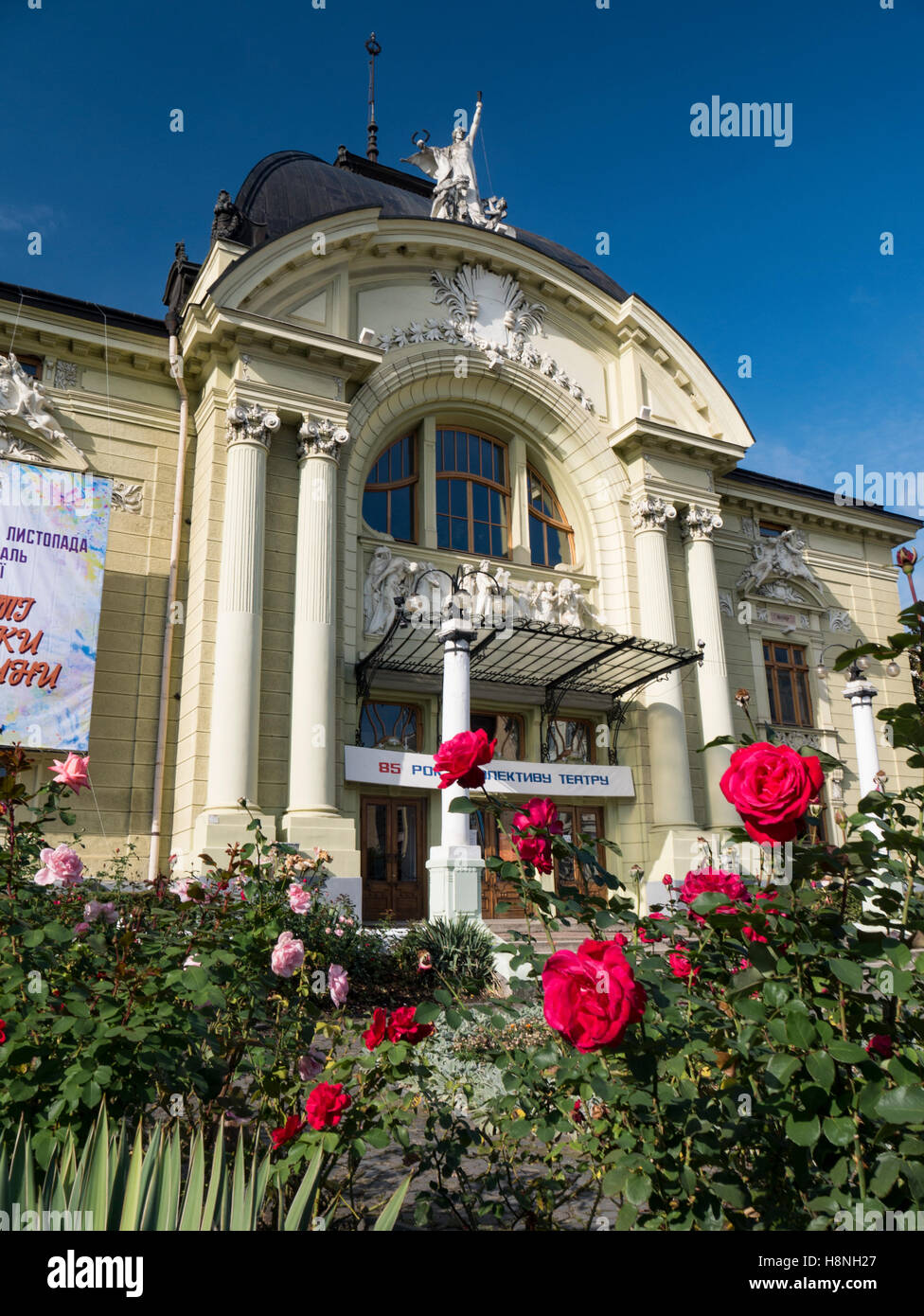 Red roses with Chernivtsi Drama Theatre Ukraine Front of Chernivtsi Drama Theatre  in the background. Chernivtsi Oblast Ukraine Stock Photo