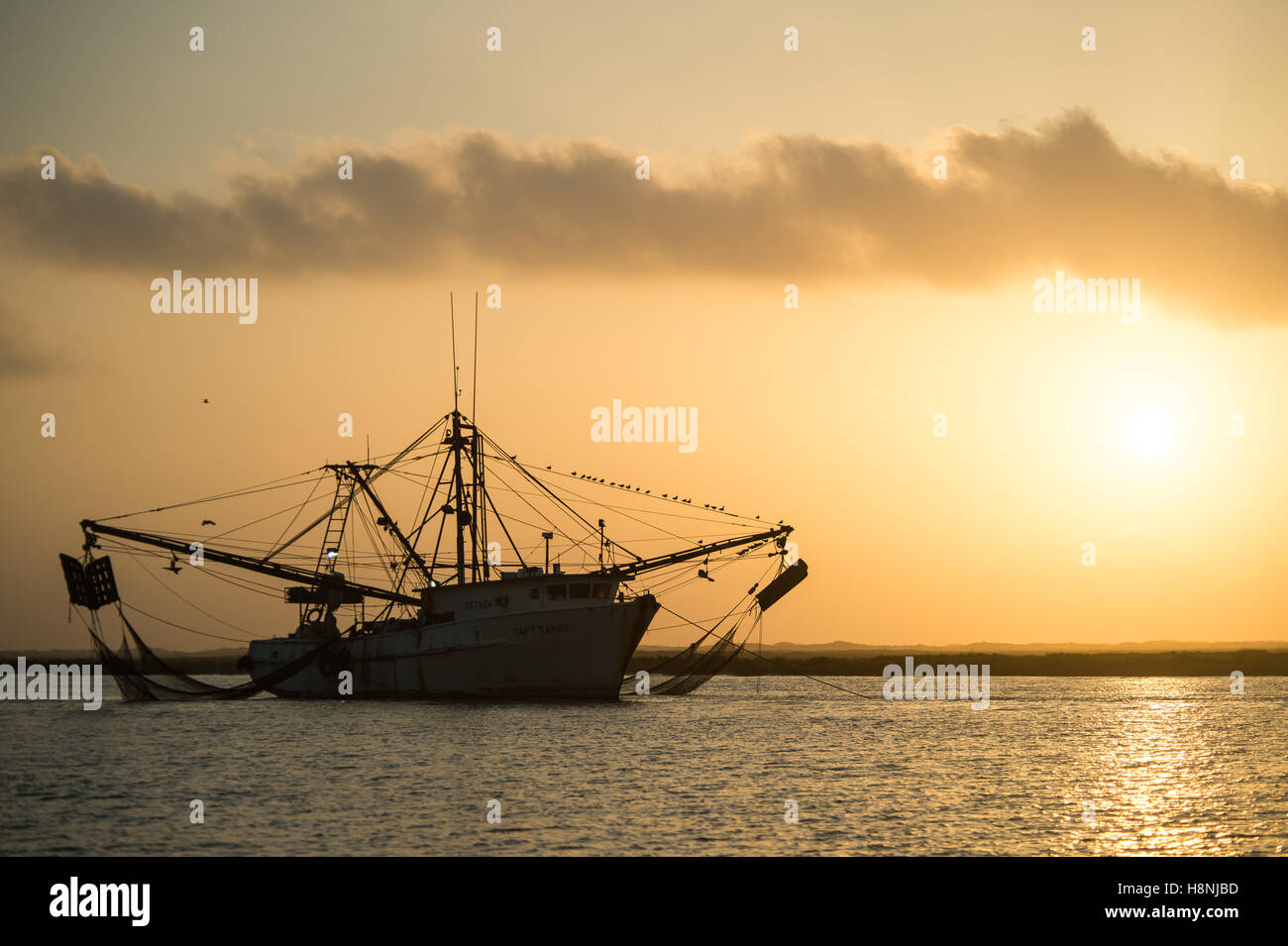 Shrimp boat at sunrise near Port Aransas Texas Stock Photo