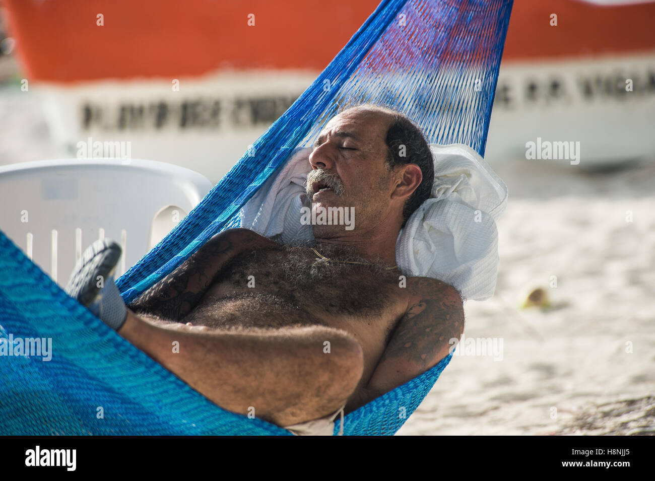 Man sleeping in a hammock on the beach Stock Photo