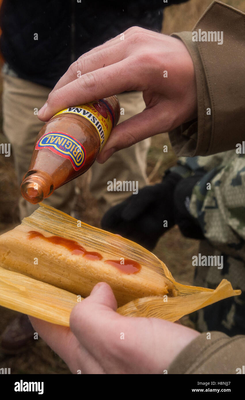 Pouring hot sauce on a tamale Stock Photo Alamy