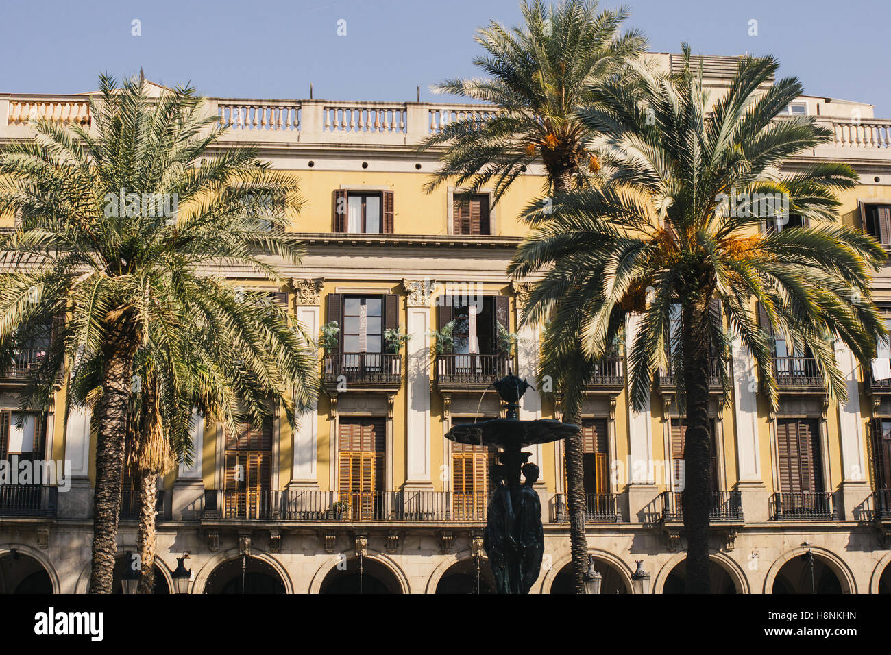 A building and palm trees on the Placa Reial in Barcelona, Spain. Stock Photo