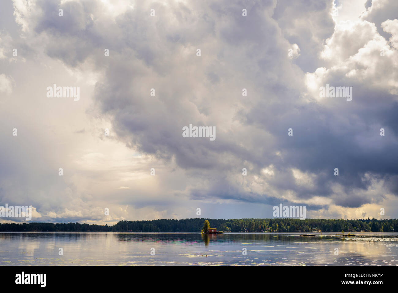 Lake among forests with little house on island Stock Photo