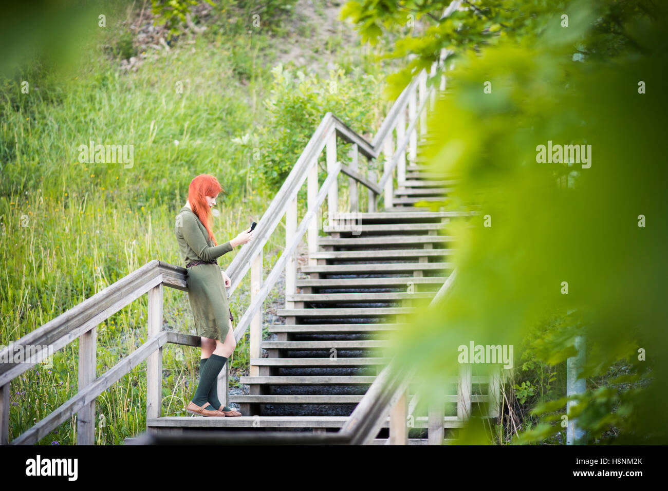 Redhaired woman standing on staircase Stock Photo