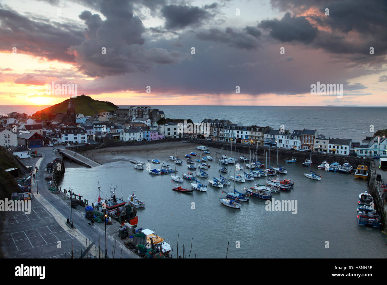 Sunset and distant shower clouds at Ilfracombe harbour in Devon, England. Stock Photo