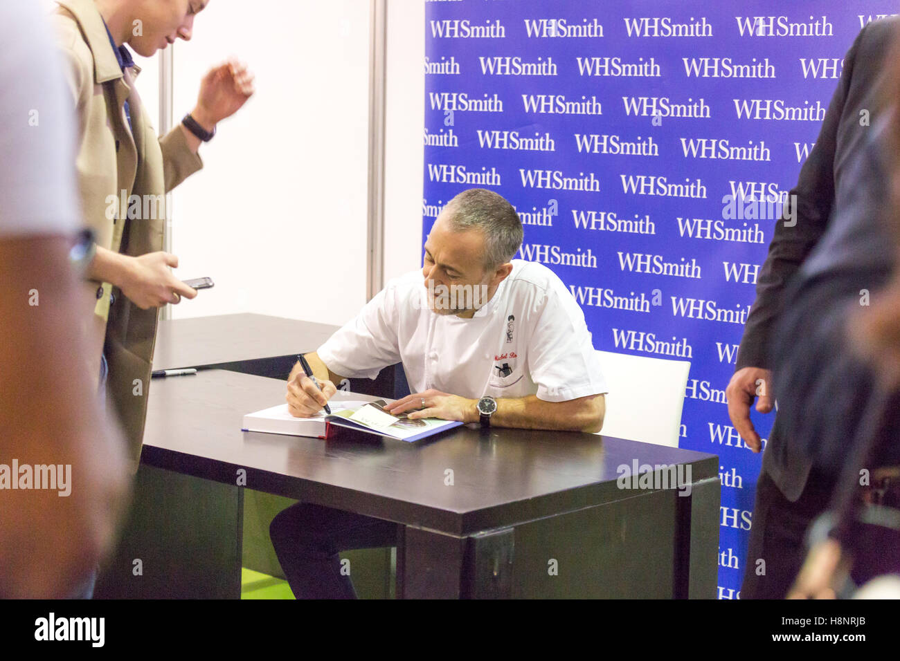 Michel Roux Jr signs his book for a fan during the BBC Good Food Show at Olympia London. Stock Photo